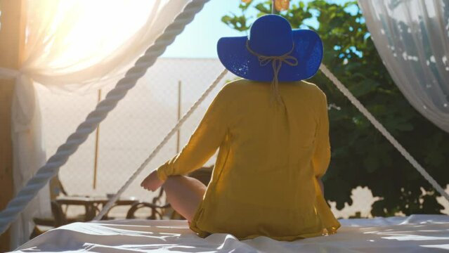 Woman relaxing on the hanging canopy bed.