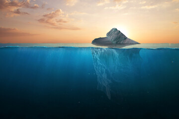 Ocean warming, concept. Iceberg in clear blue water and hidden danger under water at sunset....