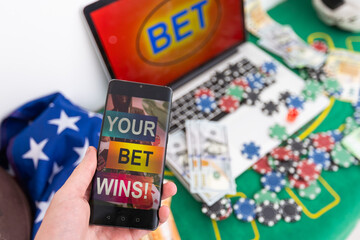 Sports betting website in a mobile phone screen while woman holds the device.