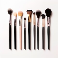 A set of makeup brushes and tools arranged artistically on a white background