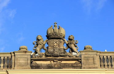 Fototapeta na wymiar Sculpted Detail with Two Lions and a Crown on the Roof of the Logement van Amsterdam Building in The Hague, Netherlands