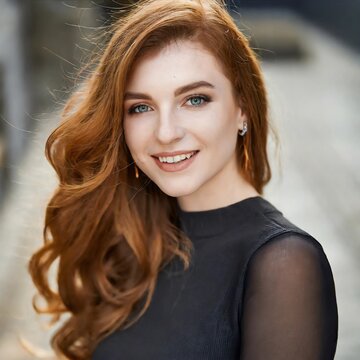 Mujer pelirroja, ojos azules y pecas, sonriendo. Con la piel clara. Cauc&aacute;sica.