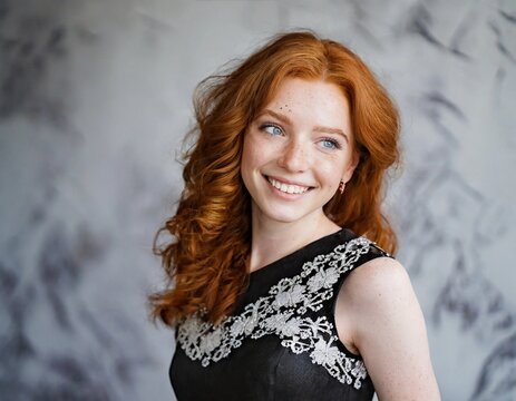 Mujer pelirroja, ojos azules y pecas, sonriendo. Con la piel clara. Cauc&aacute;sica.