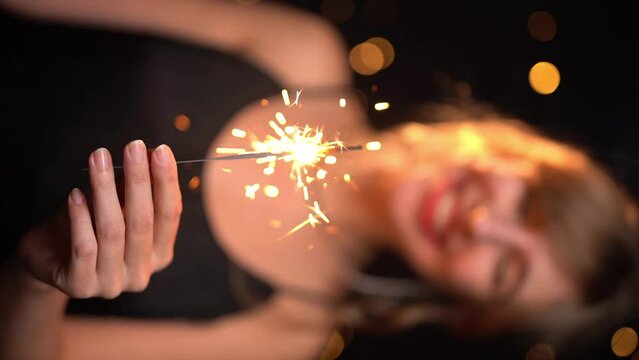 girl holding sparkler and smiling. new year or birthday party celebration party. Vertical reel format slow motion video footage