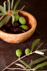 a wooden bowl with olives