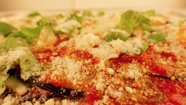 melanzane di parmigiana is a classic Southern Italian dish prepared by thinly fried eggplant slices coated with cheese and tomato sauce and baked in the oven