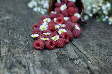Raspberries are scattered on a wooden table