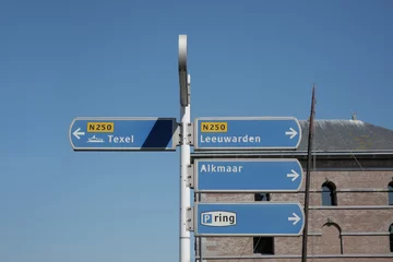 Fototapeten Directional road signs at Willemsoord in Den Helder in the Netherlands, pointing to Texel, Leeuwarden, and Alkmaar © StandbildCA