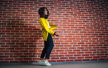 A woman standing in front of a brick wall. The Serene Strength of a Woman Against the Timeless...