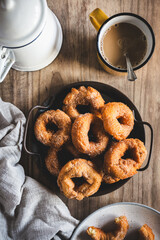 vista superior de una bandeja con rosquillas (donut español) junto a una taza de café y una jarra...