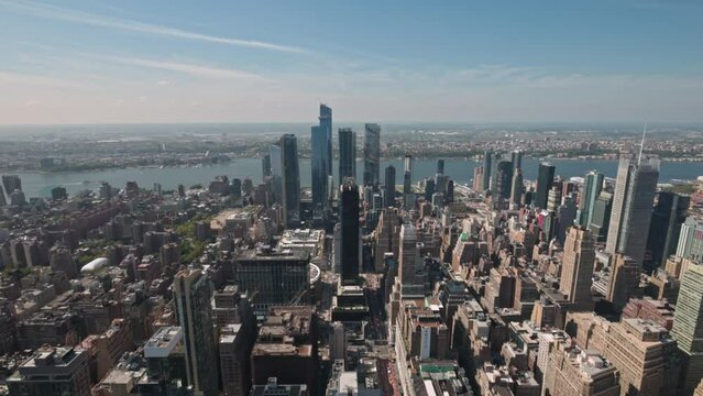 Aerial view from Empire State Building overlooking rooftops of skyscrapers and bustling 34th Street in Manhattan, with iconic Macy's department store. New York. USA