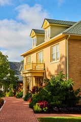 Red brick path on refinanced yellow home with mortgage on house or apartment, pretty summer day