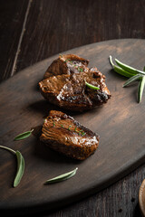 Fried pieces of meat on a dark wooden tray