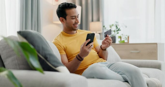 Credit card, phone and man doing online purchase from couch in a home as ecommerce with internet to relax. Happy, website and person buying on the web or banking on app on living room sofa to pay