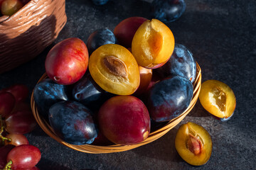 pink and blue plums in a basket