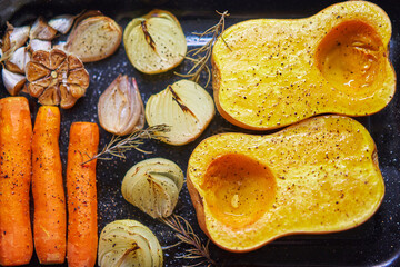 Roasted ingredients for cooking vegetarian creamy pumkin soup consist from carrots, onion, pumpkin...