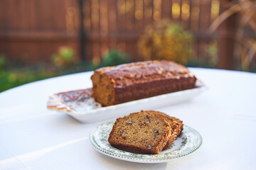 Homemade banana bread with pecan nuts served as a delicious and tasty breakfast or snack outside in the garden during summer sunny morning. Ideal dish for modern healthy, lowcarb and balanced diet.