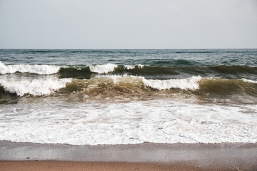 View at sea waves on a beach with massive foam, nature background