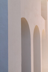View at a modern white spanish building with arches in sunlight, minimalistic style photography
