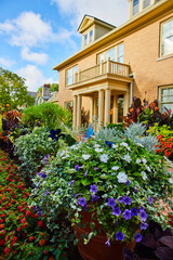 Fototapeta na wymiar Gorgeous flower garden on refinanced yellow home with mortgage on house or apartment