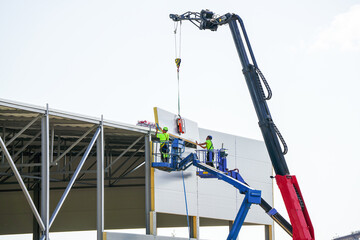 Sandwich panels wall assembly using telescopic boom crane and two self propelled articulating lifts