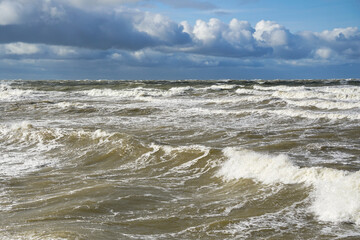 Stormy weather seascape, big waves with foam, low dark cumulus clouds, stormy sea view