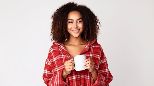 Image of pleased smiling woman looking at the camera wearing plaid pajamas while drinking morning coffee isolated on white background.