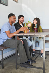 Fototapeta premium Friends drinking tea at cafe from plastic cups with straws