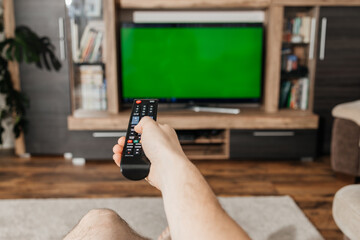 Close-up of a man's hands holding a TV remote control. Watching TV