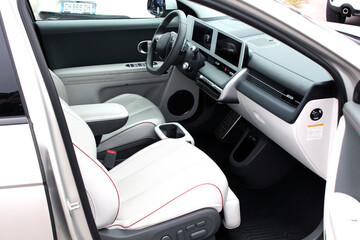 Interior new electric car. Electric car interior details. Electric car dashboard. White leather interior modern electric car. 