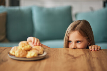 Obraz na płótnie Canvas Portrait of a little girl eating a cake at home