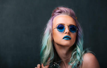 A woman with blue and green hair wearing sunglasses. Colorful Hair and Cool Shades: A Fashionable...