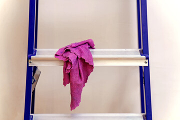 Pink wet cloth lying on stepladder during renovation