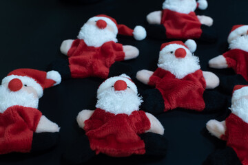 Funny Santa Claus toys lying on black table background