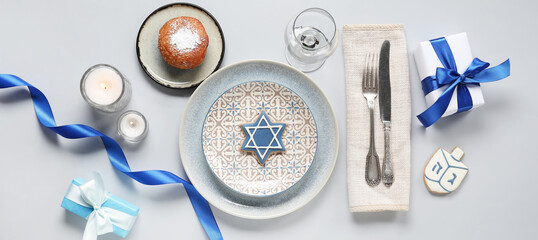 Festive table setting for Hanukkah dinner on light background