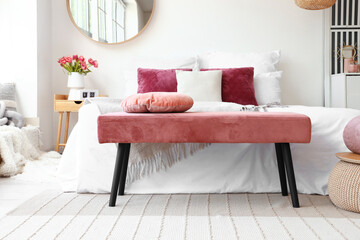 Interior of light bedroom with pink bench