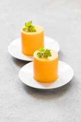 Carrot cream pudding cylindrical shape, with parsley.