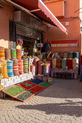 Typical shop in the city of Marrakech, with bags of spices outside the shop and a nice cartes.