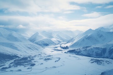 Fototapeta premium A serene valley with a river, nestled between snow-capped mountains under a pale blue sky.