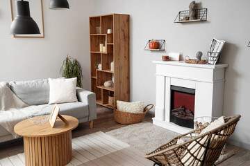 Interior of modern living room with fireplace, grey sofa and chairs