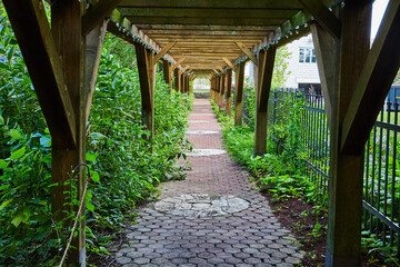 Wooden trellis walkway through garden with black fence, Minnetrista Museum and Gardens