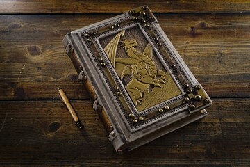 White leather book with the dragon symbol in wooden part of the cover, framed with a brass frame...