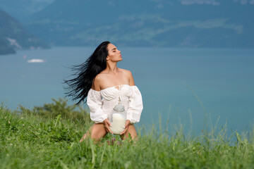 Sexy Milk. Young woman in lingerie drinking milk outside. Model drink Milk near green grass an Alpine lake. Young woman drinking milk from bottle on alpine mountain. Farm on Switzerland.