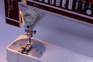 Sewing on a machine repairing clothes. A seamstress sews on a machine in a sewing room