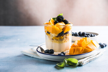 Trifle dessert with berries and cream on wooden table. Copy space