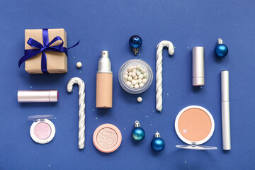 Christmas composition with different makeup products on blue background