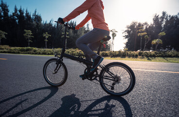Fototapeta premium Riding folding bike on sunny seaside road