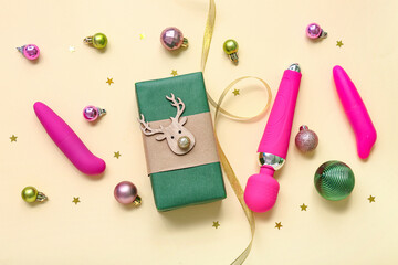 Vibrators with gift box and Christmas decor on beige background