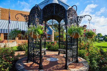 Cheerful black garden gazebo with hanging plants and flowers at Minnetrista Museum and Gardens