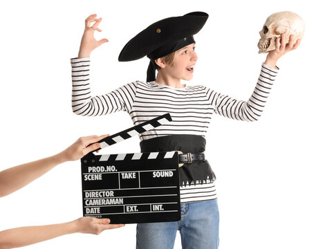 Little actor dressed as pirate and hands with movie clapper on white background